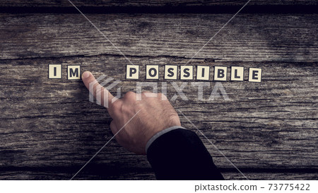 Businessman diving impossible letter tiles sign into possible Businessman diving impossible letter tiles sign into possible 73775422