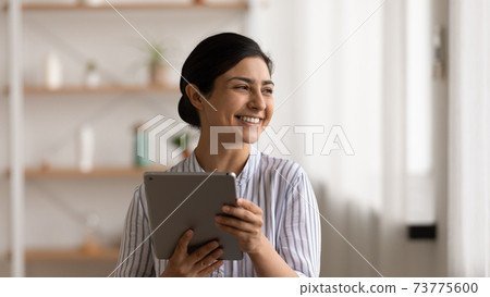 Positive indian female enjoy possibilities of modern digital tablet 73775600