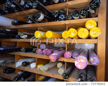Glassy colorful rods. Wooden stand with pigment glass rods 73776041