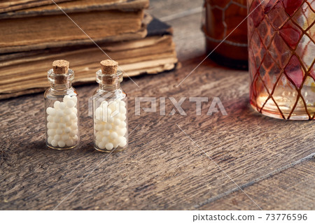 Two transparent bottles of homeopathic globules with copy space 73776596