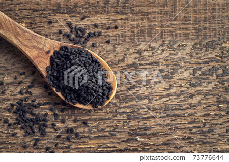 Black cumin seeds on a spoon, top view with copy space Black cumin seeds on a spoon, top view with copy space 73776644