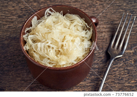 Fermented white cabbage in a pot on a table Fermented white cabbage in a pot on a table 73776652