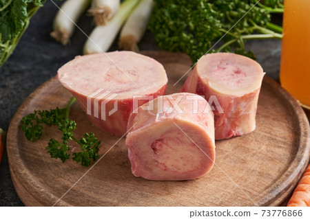 Ingredients for preparing beef bone broth or soup - fresh marrow bones and vegetables Ingredients for preparing beef bone broth or soup - fresh marrow bones and vegetables 73776866