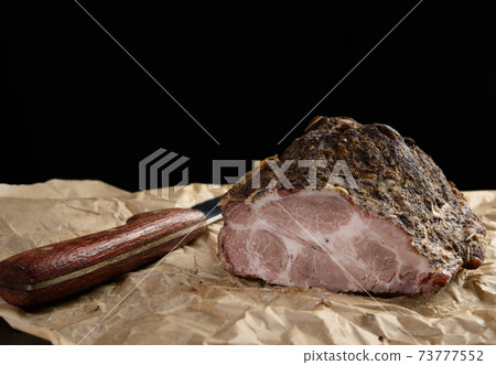 a baked piece of spiced pork neck on brown parchment paper a baked piece of spiced pork neck on brown parchment paper 73777552