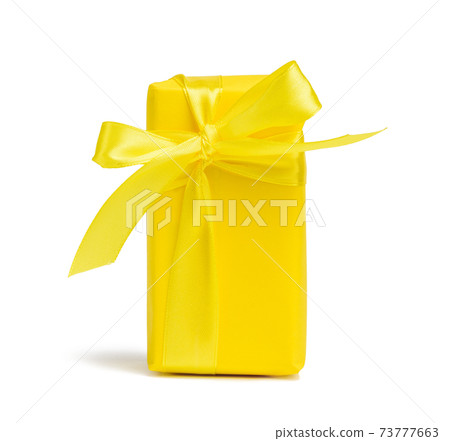 rectangular box with a gift wrapped in yellow paper and tied with a silk yellow ribbon rectangular box with a gift wrapped in yellow paper and tied with a silk yellow ribbon 73777663