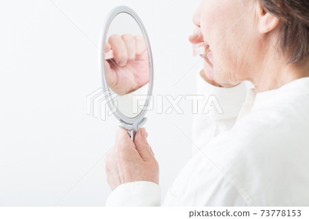 Senior woman brushing teeth Senior woman brushing teeth 73778153