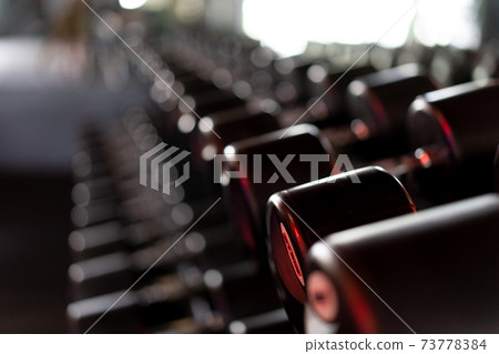 Dumbbells in a row at gym Dark toned Dumbbells in a row at gym Dark toned 73778384