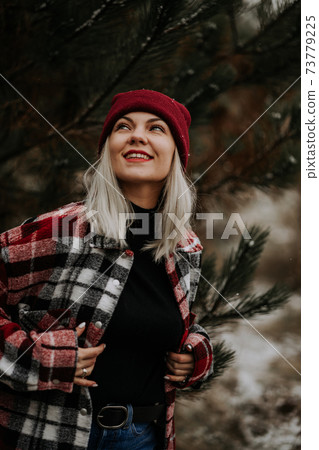 Portrait of young pretty woman in forest, winter season. Attractive kind girl smiling, lady in Portrait of young pretty woman in forest, winter season. Attractive kind girl smiling, lady in 73779225