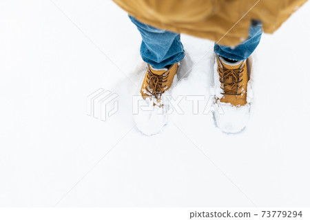 Boy's winter boots closeup on snowy background Boy's winter boots closeup on snowy background 73779294