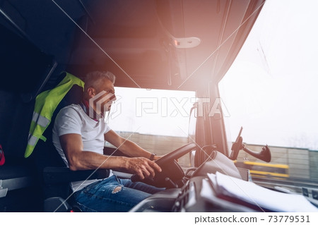 Semi Truck Driver Job. The man behind the wheel. Semi Truck Driver Job. The man behind the wheel. 73779531