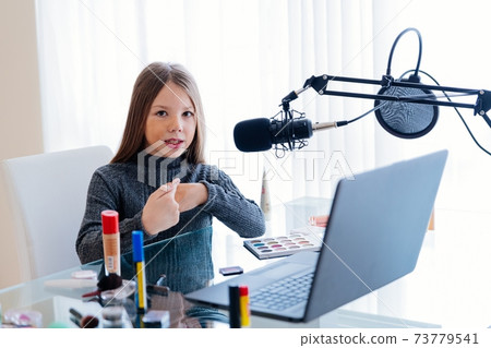 Beautiful young teen blogger or vlogger showcases her cosmetics. 73779541