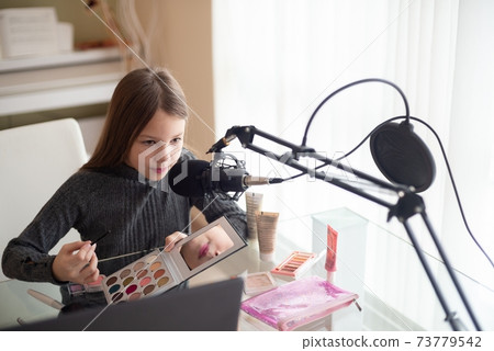 Young vlogger talking about makeup eye shadow. 73779542