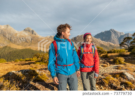 Hiking people walking living healthy outdoor active lifestyle doing hike at Routeburn Track. Multiethnic hikers with backpacks are tramping on Key Summit Track at Fiordland National Park, New Zealand 73779730
