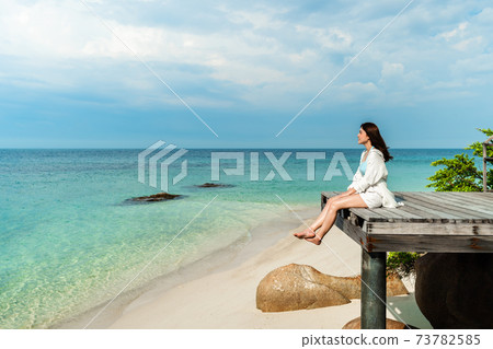 happy woman sitting on wooden bridge in the sea beach at Koh MunNork Island, Rayong, Thailand happy woman sitting on wooden bridge in the sea beach at Koh MunNork Island, Rayong, Thailand 73782585