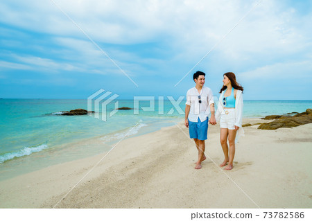 happy young couple walking on sea beach at Koh MunNork Island, Rayong, Thailand happy young couple walking on sea beach at Koh MunNork Island, Rayong, Thailand 73782586