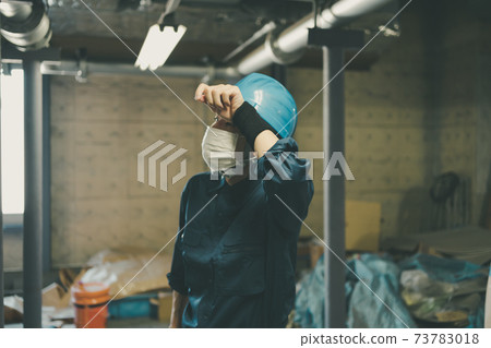 Factory worker wiping sweat with a wristband 73783018