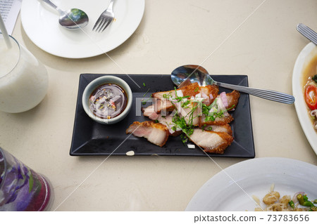 Juicy Grill pork with spicy sauce (Thai style) in black dish 73783656