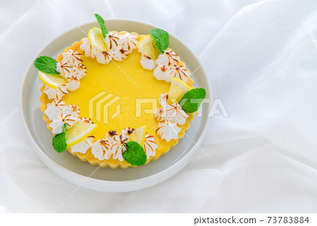 Lemon Tart citrus cake in white dish and white cloth background, Lemon Tart citrus cake in white dish and white cloth background, 73783884