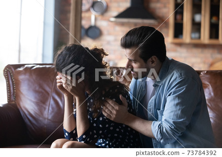 Loving husband hug comfort unhappy crying wife 73784392