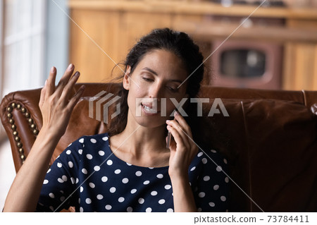 Young woman sit at home talk on smartphone Young woman sit at home talk on smartphone 73784411