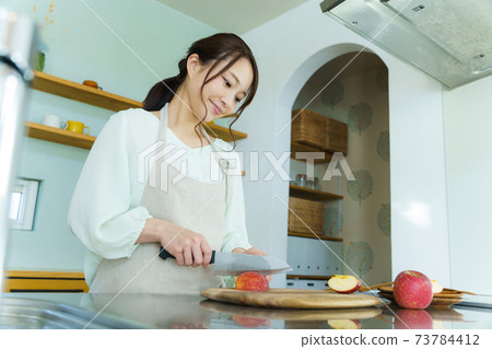 Woman cutting fruit, housewife, mom 73784412