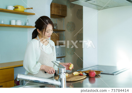Woman cutting fruit, housewife, mom 73784414