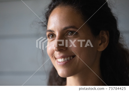 Close up of smiling woman look in distance dreaming 73784425