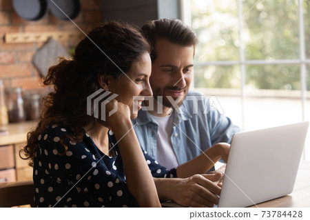 Happy couple use laptop shopping online on gadget 73784428
