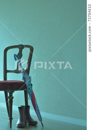 桃花心木椅子在一個昏暗的屋子裡有五顏六色的傘和雨靴的英國家具(生動的口氣,軟的焦點) 桃花心木椅子在一個昏暗的屋子裡有五顏六色的傘和雨靴的英國家具(生動的口氣,軟的焦點) 73784810