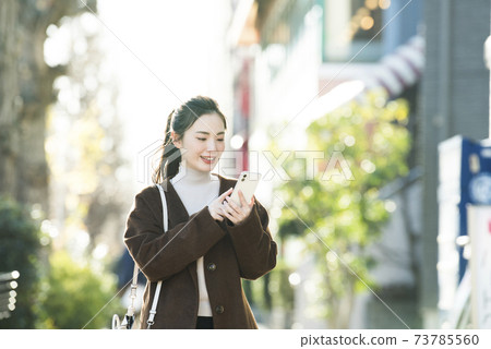 尋找在她的智能手機上一個年輕女子目的地 73785560