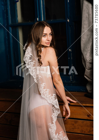 Morning of the bride. Portrait of a beautiful young female in a white underwear. Morning of the bride. Portrait of a beautiful young female in a white underwear. 73785680