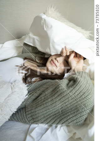 A woman relaxing in bed 73785810