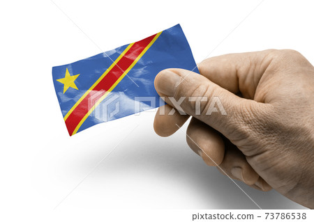 Hand holding a card with a national flag the Democratic Republic of the Congo Hand holding a card with a national flag the Democratic Republic of the Congo 73786538