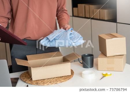 Asian business owner working at home with packing box of his online store prepare to deliver products to customers, alpha generation life style concept. 73786794