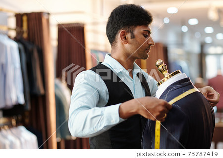 Tailor measuring jacket shoulders Tailor measuring jacket shoulders 73787419