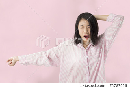 woman wear pink pajamas yawn and stretch when her wake up feeling sleepy woman wear pink pajamas yawn and stretch when her wake up feeling sleepy 73787926