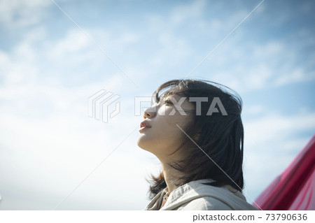 Portrait of a woman looking up at the sky Portrait of a woman looking up at the sky 73790636