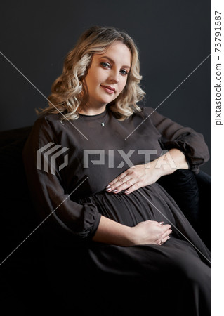 Pregnant Woman Posing In An Elegant black Dress indoors studio black wall background 73791887