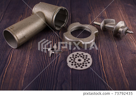 disassembled meat grinder on wooden table 73792435