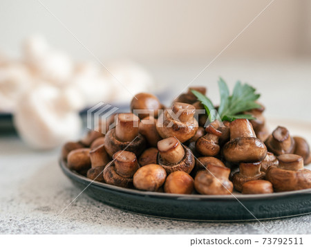 Fried mini champignons on plate, copy space 73792511
