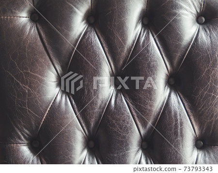 Leather sofa. Capitone or Chesterfield technique of furniture upholstery. Dark elegant furniture for lofts. Fabric background. Natural textured backdrop. Leather sofa. Capitone or Chesterfield technique of furniture upholstery. Dark elegant furniture for lofts. Fabric background. Natural textured backdrop. 73793343