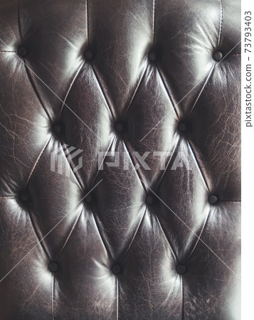 Leather sofa. Capitone or Chesterfield technique of furniture upholstery. Dark elegant furniture for lofts. Fabric background. Natural textured backdrop. Leather sofa. Capitone or Chesterfield technique of furniture upholstery. Dark elegant furniture for lofts. Fabric background. Natural textured backdrop. 73793403