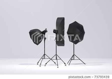 Photo studio lighting stands with flash, umbrella and softbox on the white 73793439