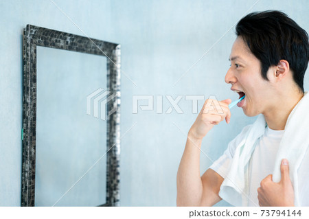 Men brushing their teeth Men brushing their teeth 73794144