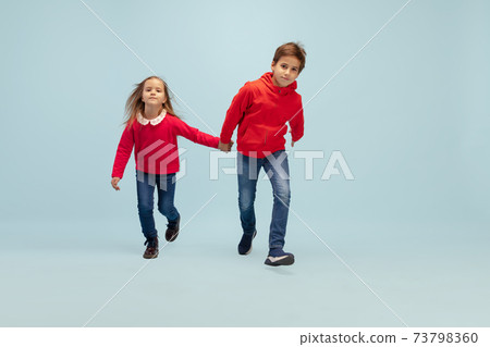 Happy children isolated on blue studio background. Look happy, cheerful, sincere. Copyspace. Childhood, education, emotions concept Happy children isolated on blue studio background. Look happy, cheerful, sincere. Copyspace. Childhood, education, emotions concept 73798360