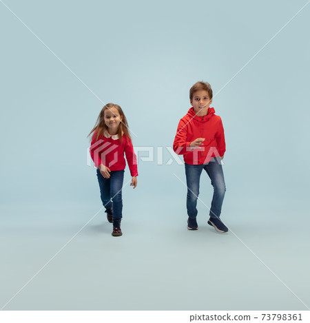 Happy children isolated on blue studio background. Look happy, cheerful, sincere. Copyspace. Childhood, education, emotions concept 73798361