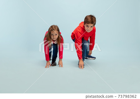 Happy children isolated on blue studio background. Look happy, cheerful, sincere. Copyspace. Childhood, education, emotions concept Happy children isolated on blue studio background. Look happy, cheerful, sincere. Copyspace. Childhood, education, emotions concept 73798362
