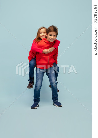 Happy children isolated on blue studio background. Look happy, cheerful, sincere. Copyspace. Childhood, education, emotions concept Happy children isolated on blue studio background. Look happy, cheerful, sincere. Copyspace. Childhood, education, emotions concept 73798363