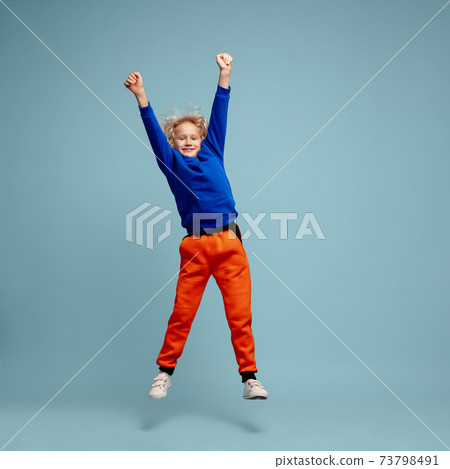 Happy curly boy isolated on blue studio background. Looks happy, cheerful, sincere. Copyspace. Childhood, education, emotions concept Happy curly boy isolated on blue studio background. Looks happy, cheerful, sincere. Copyspace. Childhood, education, emotions concept 73798491