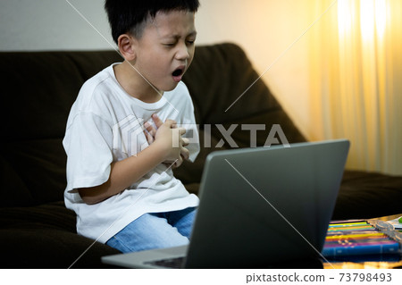Sick asian kid boy with chest pain suffering from heart attack,ill little child male having dyspnea,shortness of breath or congenital heart disease while studying online at home,health care concept Sick asian kid boy with chest pain suffering from heart attack,ill little child male having dyspnea,shortness of breath or congenital heart disease while studying online at home,health care concept 73798493